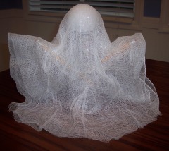Drape cheese cloth over a recycled water bottle to make a Halloween ghost craft.